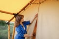 Woman close entrance of tent in glamping. Outdoor weekend. Luxury camping tent for outdoor recreation. Lifestyle concept