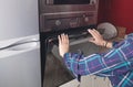 Woman close oven door in the kitchen