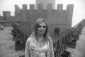 Woman close up portrait. wearing jeans jacket. Fortification on top of the mountain, old castle black and white. Mystical