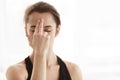 Woman with closed eyes touching ajna chakra on forehead