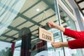 Woman closed store with sign board front door shop, Small business come back turning