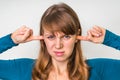 Woman closes ears with fingers to protect from loud noise Royalty Free Stock Photo