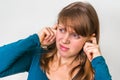 Woman closes ears with fingers to protect from loud noise Royalty Free Stock Photo