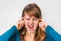 Woman closes ears with fingers to protect from loud noise Royalty Free Stock Photo