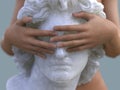 Woman closes the eyes of a statue Royalty Free Stock Photo