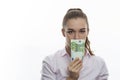 A woman closes her mouth with 100 euro money bill