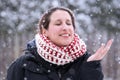 Woman closing her eyes and smiling with hand up as snow falls ge Royalty Free Stock Photo