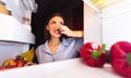 Woman closing nose near refrigerator, feeling bad smell Royalty Free Stock Photo