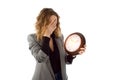 The woman clutched her head in shock while holding a large watch. Isolated on a white background. The concept of deadline, failure