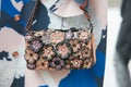 Woman with Coach leather bag with flowers decoration before Emporio Armani fashion show, Milan Fashion Week