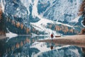 Woman on the coast of Braies lake in the morning in autumn