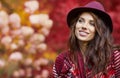 Woman in coat with hat and scarf in autumn park