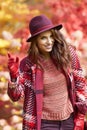 Woman in coat with hat and scarf in autumn park