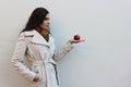 Woman in a coat holds a red juicy apple