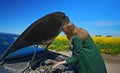 Woman in the coat opens the hood