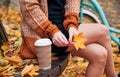 Woman with coffee is resting on bench in autumn park. Royalty Free Stock Photo