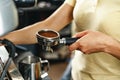 Woman coffee shop worker preparing coffee on professional coffee machine