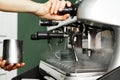 Woman coffee shop worker preparing coffee on professional coffee machine