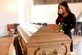 Woman with coffin crying at funeral in church Royalty Free Stock Photo