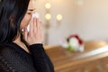 Woman with coffin crying at funeral in church Royalty Free Stock Photo