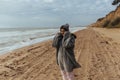 Young woman on cold autumn seashore posing at camera Royalty Free Stock Photo
