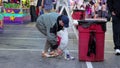 Woman collecting empty bottles at the West Coast Amusements Carnival