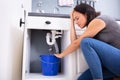 Woman Collecting Leaking Water In Bucket Royalty Free Stock Photo