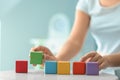 Woman with color cubes at light table, closeup