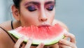 Woman with color makeup face and red melon. Young girl eat juicy watermelon. Beauty, look, visage. Summer, fruit Royalty Free Stock Photo