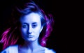 Woman in colorful bright neon blue and purple lights Royalty Free Stock Photo