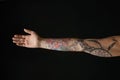 Woman with colorful tattoos on arm against background, closeup Royalty Free Stock Photo