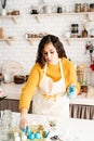 Woman coloring easter eggs blue in the kitchen Royalty Free Stock Photo