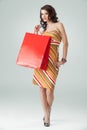 Woman colourful outfit holding red shopping bag Royalty Free Stock Photo