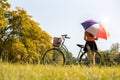 Woman with colrful umbrella and bicycle in park. People and relaxation concept. Season and Autumn theme Royalty Free Stock Photo