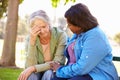 Woman Comforting Unhappy Senior Friend Outdoors Royalty Free Stock Photo
