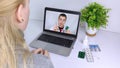 A woman communicates via a computer with a doctor via video link. Medical assistance under quarantine conditions. Remote consultat