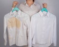 A woman compares two white shirts before and after washing. The girl is holding one blouse, clean and ironed, and the Royalty Free Stock Photo