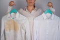 A woman compares two white shirts before and after washing. The girl is holding one blouse, clean and ironed, and the Royalty Free Stock Photo