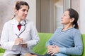 Woman complaining to doctor about tummy-ache