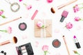 Woman composition with gift box, roses flowers, cosmetics and brushes on white background. Top view. Flat lay. Royalty Free Stock Photo