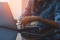 Woman hands holding electronic or stylus pencil and typing on laptop computer . Royalty Free Stock Photo