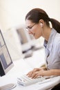 Woman in computer room listening to MP3 Player Royalty Free Stock Photo