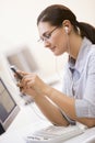 Woman in computer room listening to MP3 Player Royalty Free Stock Photo