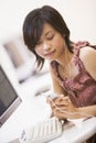 Woman in computer room listening to MP3 player Royalty Free Stock Photo