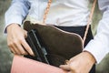 Woman hand holding removing small handgun from her purse