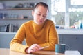 Woman Concerned About Excessive Use Of Social Media Laying Mobile Phone Down On Table