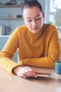 Woman Concerned About Excessive Use Of Social Media Laying Mobile Phone Down On Table