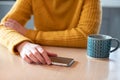 Woman Concerned About Excessive Use Of Social Media Laying Mobile Phone Down On Table