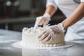 Woman confectioner makes birthday cake in gloves. Professional decorates the cake. Generative AI