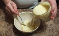 Woman confectioner pour out condensed milk to bowl